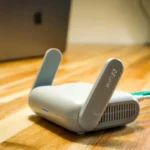 Router WiFi 6 dengan antena dan kabel di atas meja kayu